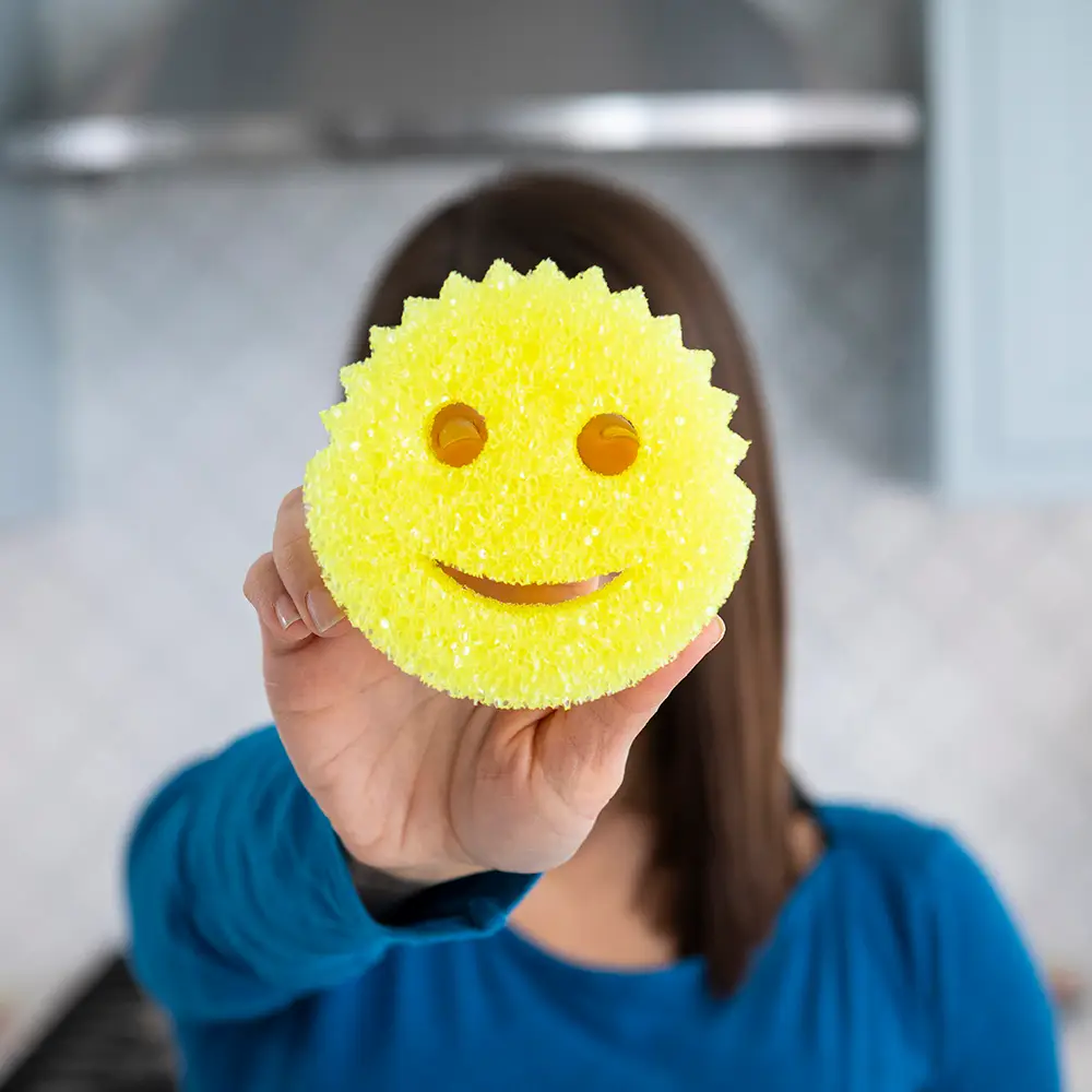Scrub Daddy yellow sponge holding by women